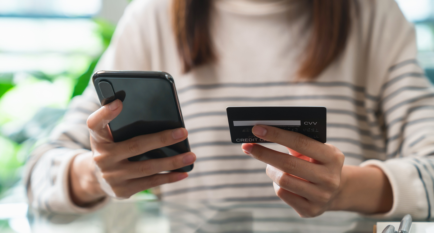 Woman hand holding credit cards and using smartphone for shopping online with payment on internet banking.